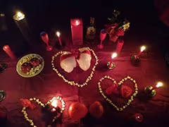 Altar com velas acesas e corações de pétalas